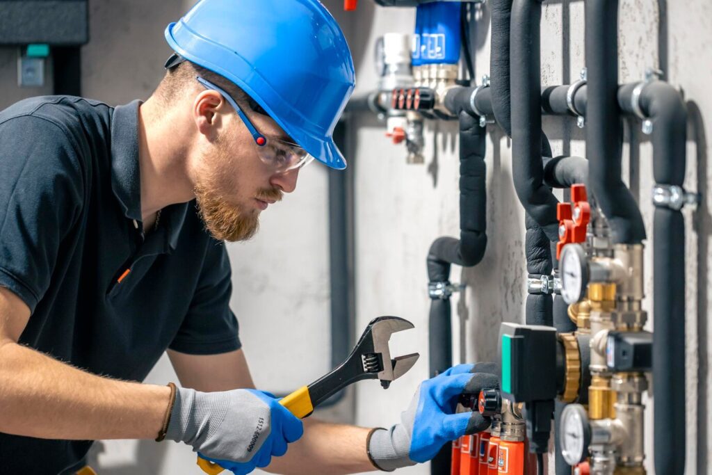 man installs heating system house checks pipes with wrench